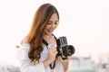 Beautiful young Asian stylish woman taking photos with retro film camera on the rooftop of a building. Asian girl smiling enjoy Royalty Free Stock Photo