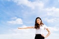 Beautiful young asian university or college student woman doing advertising or product presenting pose, copy space on blue sky Royalty Free Stock Photo