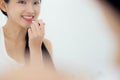 Beautiful young asian woman applying lipstick red on mouth, beauty girl looking facial at mirror for makeup cosmetic. Royalty Free Stock Photo