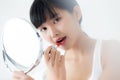 Beautiful young asian woman applying lipstick red on mouth, beauty girl looking facial at mirror for makeup cosmetic. Royalty Free Stock Photo