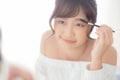 Beautiful young asian woman applying makeup eyebrows brush, beauty asia girl using cosmetic for make up style looking mirror Royalty Free Stock Photo