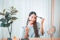 Beautiful young asian women applying and makeup on her face with brush,Beauty concept Royalty Free Stock Photo