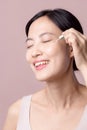 Beautiful young asian woman applying serum facial oil on natural mack up face skin. Portrait health wellness clean skincare female Royalty Free Stock Photo