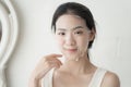 Beautiful young asian woman applying sheet facial mask and looking mirror at home, Girl applying cosmetic and makeup with skincare Royalty Free Stock Photo