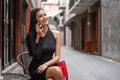 Beautiful young asian woman in black dress sitting in the coffee cafe  calling with smartphone . happy elegant lady sitting on Royalty Free Stock Photo