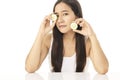 Beautiful young Asian woman cleaning beauty face, using cucumber slices cleansing lotion, and facial toner for removing makeup. A Royalty Free Stock Photo