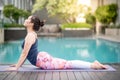 Young Asian woman doing yoga exercise near swimming pool Royalty Free Stock Photo