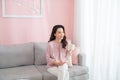 Beautiful young Asian woman drinking coffee when sitting on sofa Royalty Free Stock Photo