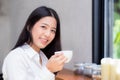 Beautiful young asian woman drinking coffee and smile in the morning at cafe Royalty Free Stock Photo