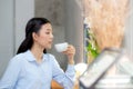 Beautiful young asian woman drinking coffee and smile in the morning at cafe, girl sitting in coffee shop Royalty Free Stock Photo