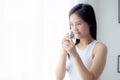 Beautiful young asian woman drinking glass of water mineral pure with fresh and happy at home. Royalty Free Stock Photo