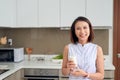 Beautiful young Asian woman drinking milk in the kitchen at home Royalty Free Stock Photo