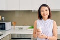 Beautiful young Asian woman drinking milk in the kitchen at home Royalty Free Stock Photo