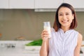 Beautiful young Asian woman drinking milk in the kitchen at home Royalty Free Stock Photo