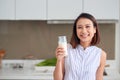 Beautiful young Asian woman drinking milk in the kitchen at home Royalty Free Stock Photo