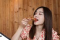 Beautiful Young asian woman eating delicious or yummy pizza