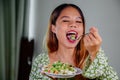 beautiful young asian woman eating healthy mediterranean food. smiling happy girl eating greek salad Royalty Free Stock Photo