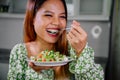 beautiful young asian woman eating healthy mediterranean food. smiling happy girl eating greek salad Royalty Free Stock Photo