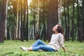 A beautiful woman enjoy listening to music with headphone with feeling happy and relaxed in the park Royalty Free Stock Photo