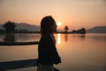 Beautiful young asian woman enjoying with sunrise on mountain lake Royalty Free Stock Photo