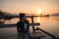 Beautiful young asian woman enjoying with sunrise on mountain lake Royalty Free Stock Photo