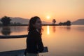 Beautiful young asian woman enjoying with sunrise on mountain lake Royalty Free Stock Photo