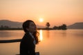 Beautiful young asian woman enjoying with sunrise on mountain lake Royalty Free Stock Photo