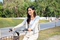 Beautiful young Asian woman enjoys riding a bicycle in the beautiful park on her weekend Royalty Free Stock Photo