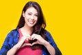 Beautiful young asian woman giving love or heart to customer or people by using hands for making heart shaped with smiley face. Royalty Free Stock Photo