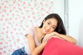 Beautiful young asian woman happy and smiling face and looking to camera sitting on sofa Royalty Free Stock Photo
