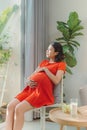 Beautiful young Asian woman is happy to take care of newborn child in future. Modern healthy mom concept