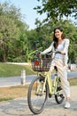 Beautiful young Asian woman with her bicycle in the city park. activity and leisure concept Royalty Free Stock Photo