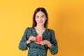 Beautiful young Asian woman hold coffee feel warm with hot red cup stand on yellow background in studio, portrait attractive lady