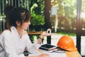 Beautiful young Asian woman holding house model while sitting in front of her working place Royalty Free Stock Photo