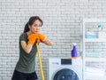Beautiful young Asian woman, housewife wearing orange protective rubber gloves during cleaning Royalty Free Stock Photo