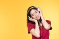 Beautiful young asian woman joyful listening to music on headphones isolated on pastel yellow wall background studio portrait Royalty Free Stock Photo