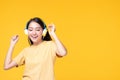 Beautiful young asian woman joyful listening to music on headphones isolated on pastel yellow wall background studio portrait Royalty Free Stock Photo