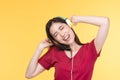 Beautiful young asian woman joyful listening to music on headphones isolated on pastel yellow wall background studio portrait Royalty Free Stock Photo