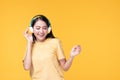 Beautiful young asian woman joyful listening to music on headphones isolated on pastel yellow wall background studio portrait Royalty Free Stock Photo