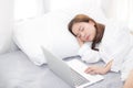 Beautiful young asian woman with laptop lying down in bedroom, girl tired sleep with computer notebook. Royalty Free Stock Photo