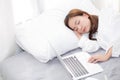 Beautiful young asian woman with laptop lying down in bedroom, girl tired sleep with computer notebook. Royalty Free Stock Photo