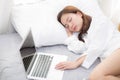 Beautiful young asian woman with laptop lying down in bedroom, girl tired sleep with computer notebook. Royalty Free Stock Photo