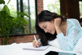 Beautiful young asian woman laying on bed and writing a diary Royalty Free Stock Photo