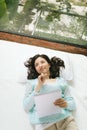 Beautiful young asian woman laying on bed and writing a diary Royalty Free Stock Photo