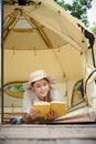Beautiful young Asian woman laying in the camping tent and reading a book Royalty Free Stock Photo