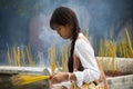 Beautiful young woman lighting incense sticks