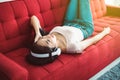 Beautiful young asian woman listening to music with headphones while lying on sofa Royalty Free Stock Photo