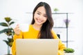 Beautiful young asian woman looking at computer screen watching webinar