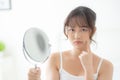 Beautiful young asian woman looking the mirror with acne problem at bedroom, trouble of beauty on face Royalty Free Stock Photo