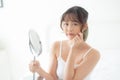 Beautiful young asian woman looking the mirror with acne problem at bedroom, trouble of beauty on face Royalty Free Stock Photo